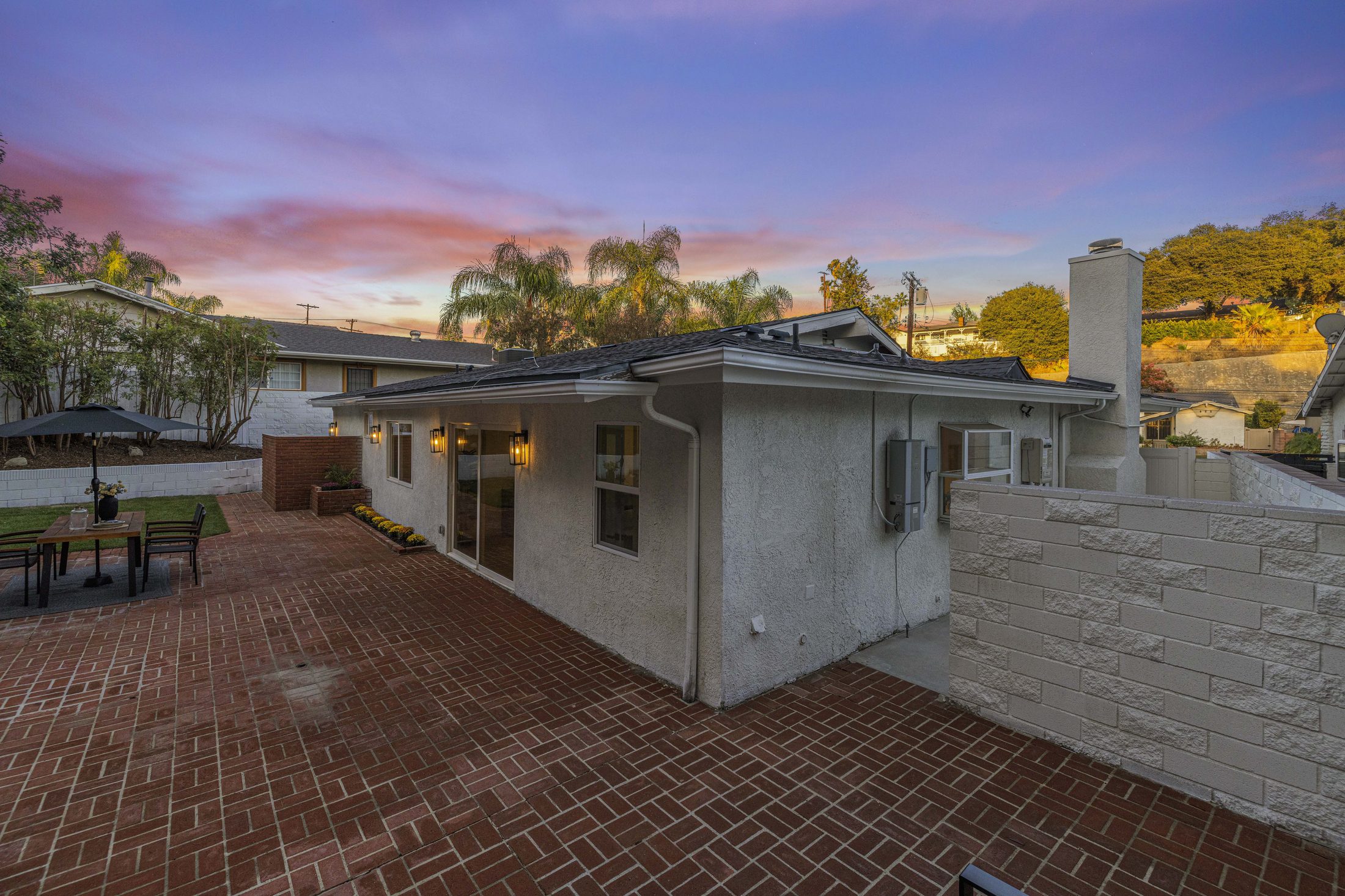 Rear elevation of the home at dusk from the brick patio