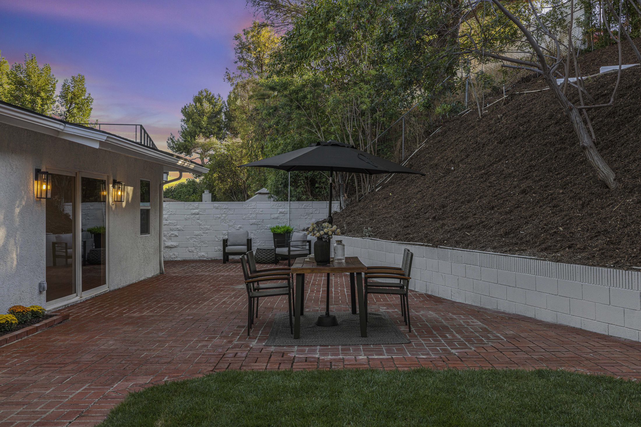 Brick patio with outdoor dining table and umbrella